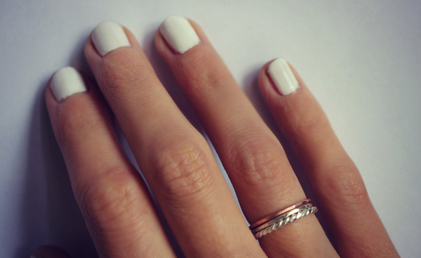 Set of three sterling silver and rose gold stacking rings, silver twist, rose gold and hammered.